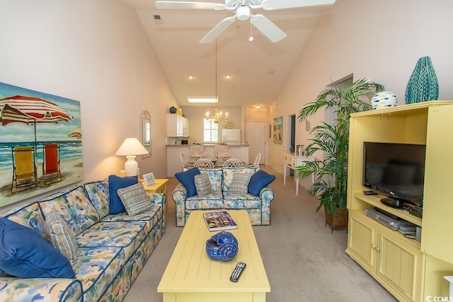 living room with high vaulted ceiling, ceiling fan with notable chandelier, and light colored carpet