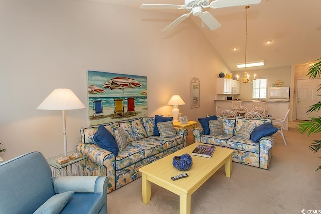 living room with light colored carpet, high vaulted ceiling, and ceiling fan with notable chandelier