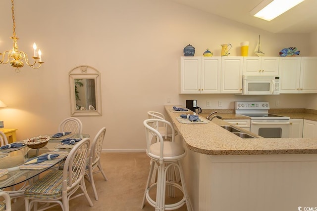 kitchen with sink, white cabinetry, vaulted ceiling, hanging light fixtures, and white appliances