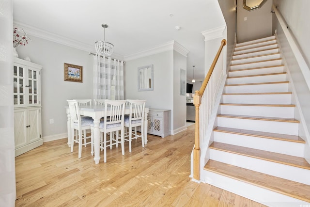 dining space featuring a notable chandelier, ornamental molding, and light hardwood / wood-style floors