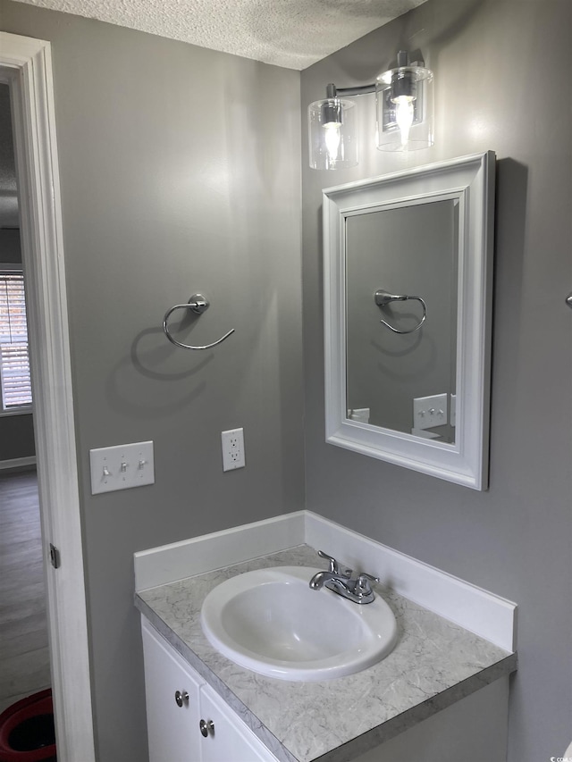 bathroom featuring a textured ceiling and vanity