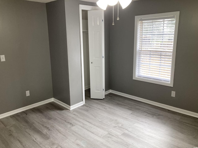 unfurnished bedroom with baseboards and wood finished floors