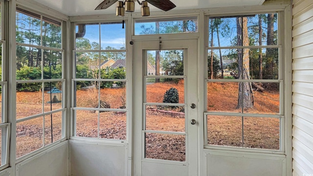 unfurnished sunroom featuring ceiling fan