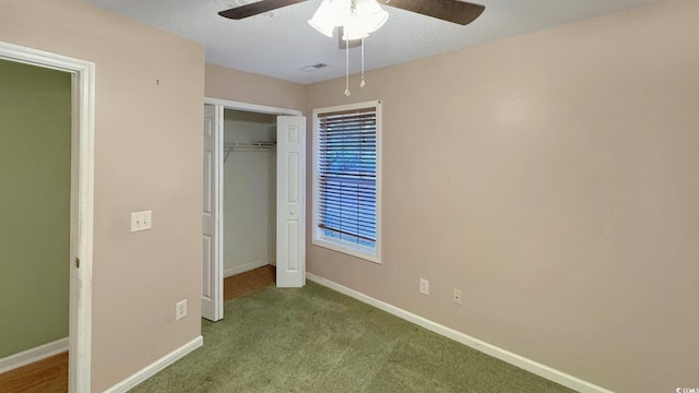 unfurnished bedroom featuring ceiling fan, light colored carpet, a closet, and a textured ceiling