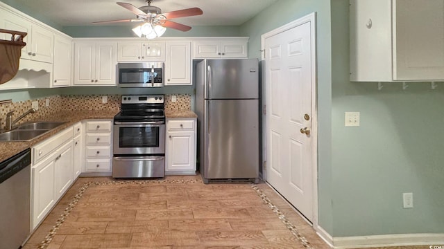 kitchen with sink, white cabinetry, light hardwood / wood-style flooring, ceiling fan, and stainless steel appliances