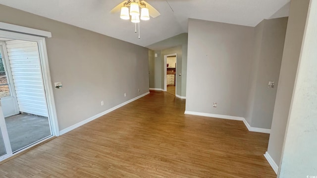 empty room with ceiling fan, vaulted ceiling, and light hardwood / wood-style flooring