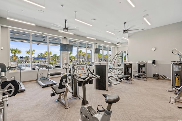 gym featuring electric water heater, light colored carpet, and ceiling fan