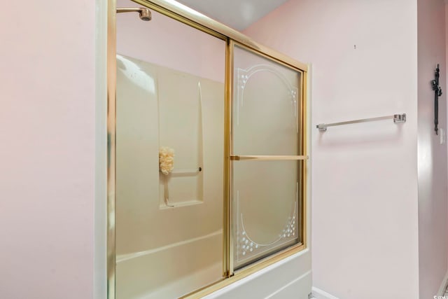 bathroom featuring bath / shower combo with glass door