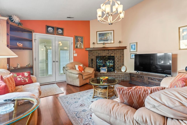 living room with visible vents, lofted ceiling, wood finished floors, french doors, and a brick fireplace