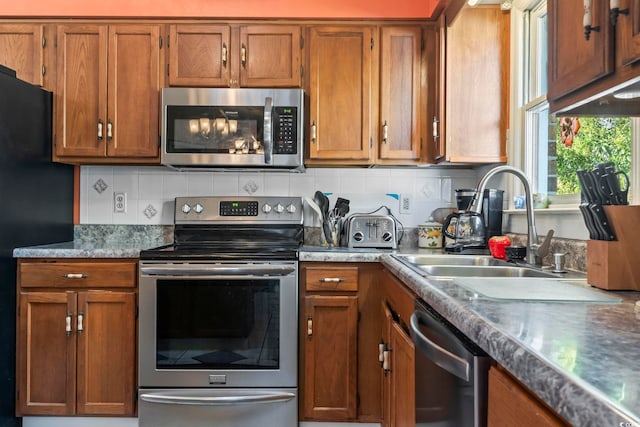 kitchen featuring stainless steel appliances, brown cabinets, and a sink