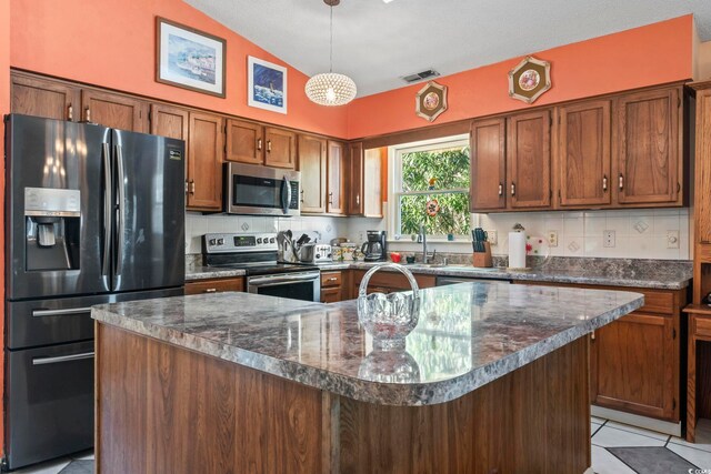 kitchen featuring open floor plan, plenty of natural light, stainless steel dishwasher, and an inviting chandelier