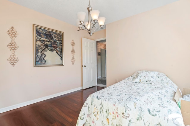 bedroom featuring dark wood-style floors, baseboards, and an inviting chandelier