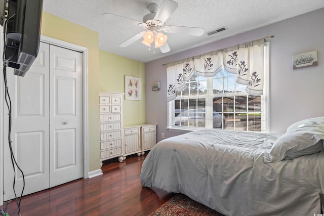 bedroom featuring a textured ceiling, dark wood-type flooring, a closet, and visible vents