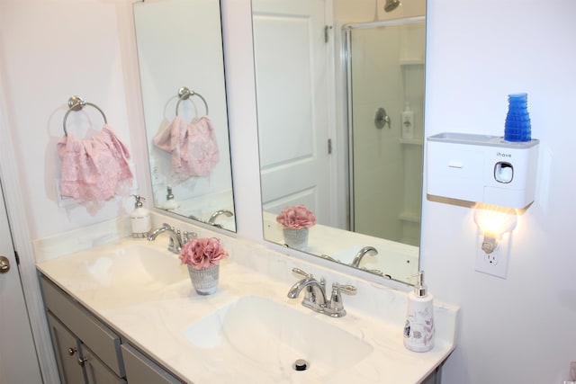 bathroom featuring a shower with door and vanity