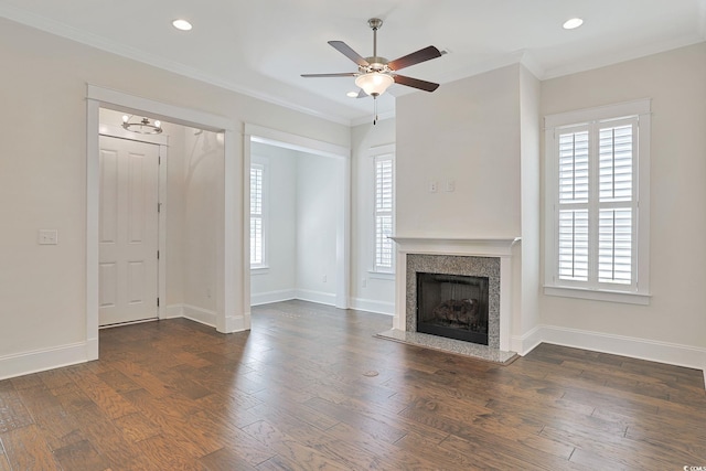 unfurnished living room with a fireplace with raised hearth, baseboards, wood finished floors, and crown molding