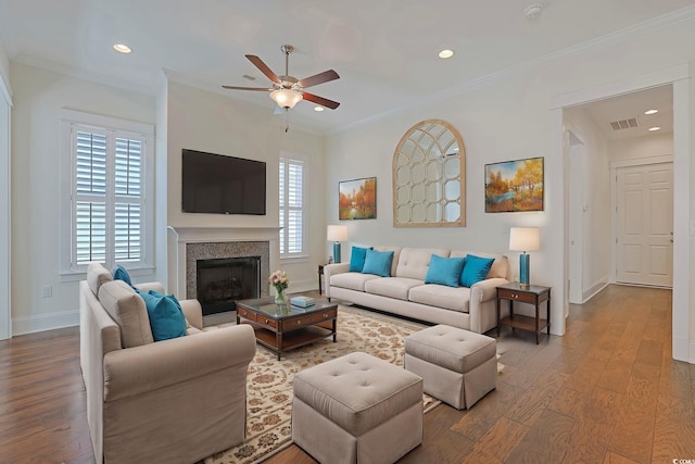 living room featuring baseboards, plenty of natural light, ornamental molding, and wood finished floors