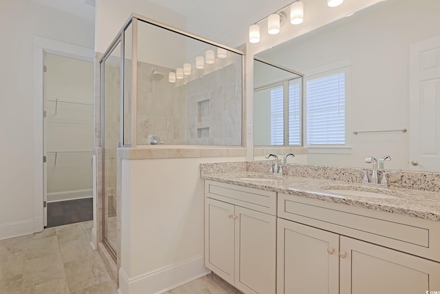 bathroom featuring a stall shower, a sink, a spacious closet, and double vanity