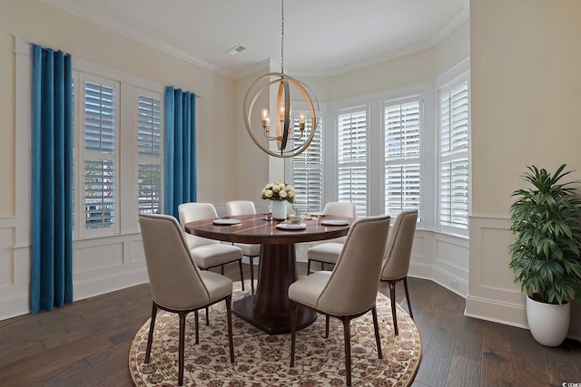 dining room with dark wood-style floors, a chandelier, a decorative wall, and crown molding