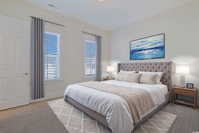 bedroom with carpet floors, visible vents, and baseboards