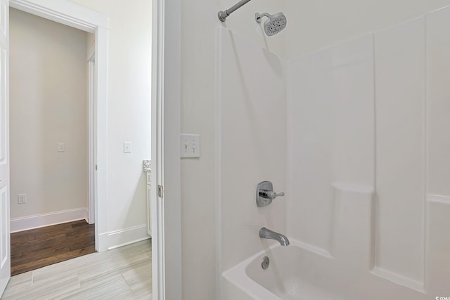 full bathroom featuring shower / tub combination, baseboards, and wood finished floors