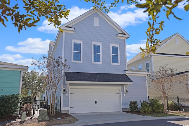 traditional-style home with a garage, fence, concrete driveway, and roof with shingles