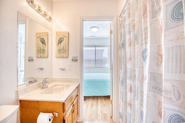 bathroom with hardwood / wood-style flooring, vanity, and toilet