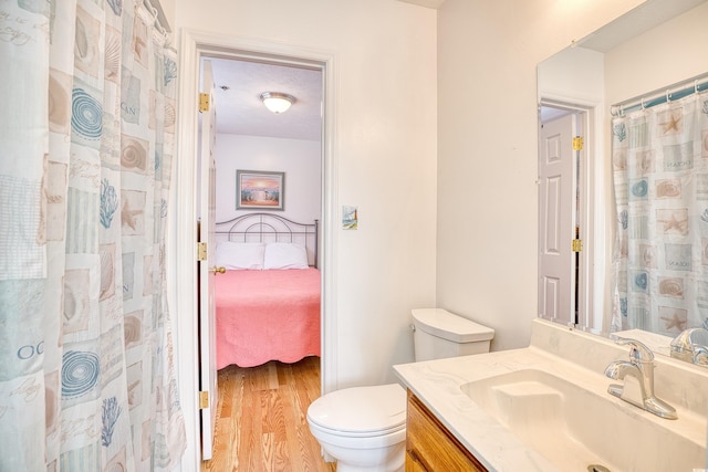 bathroom with vanity, hardwood / wood-style floors, and toilet