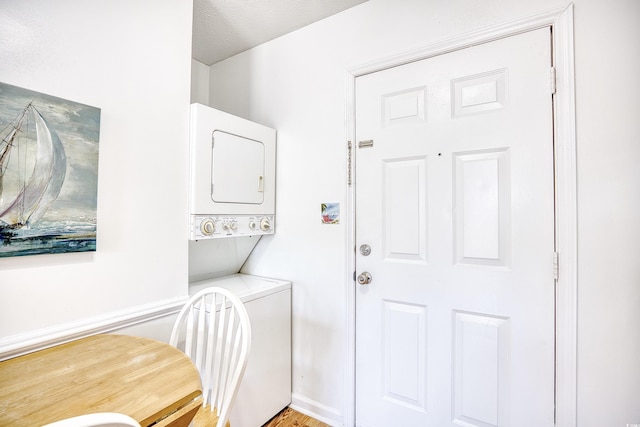 laundry area featuring stacked washer / drying machine