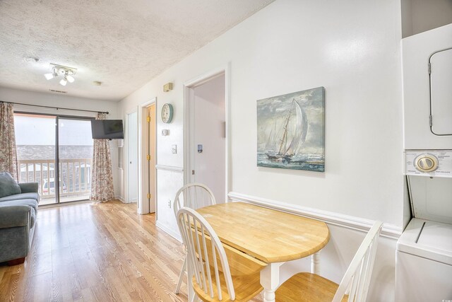 dining space featuring light hardwood / wood-style floors and a textured ceiling