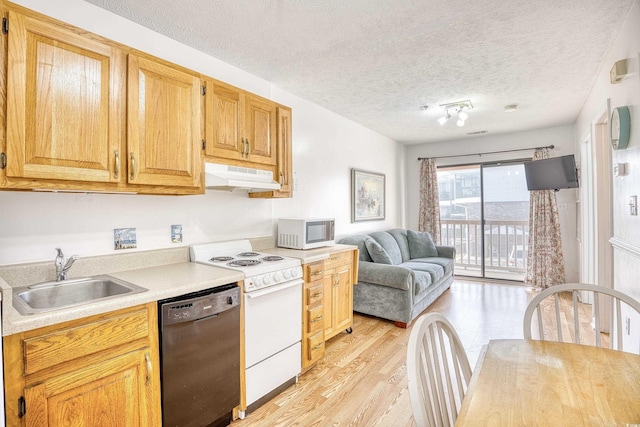 kitchen featuring white appliances, light hardwood / wood-style floors, sink, and a textured ceiling