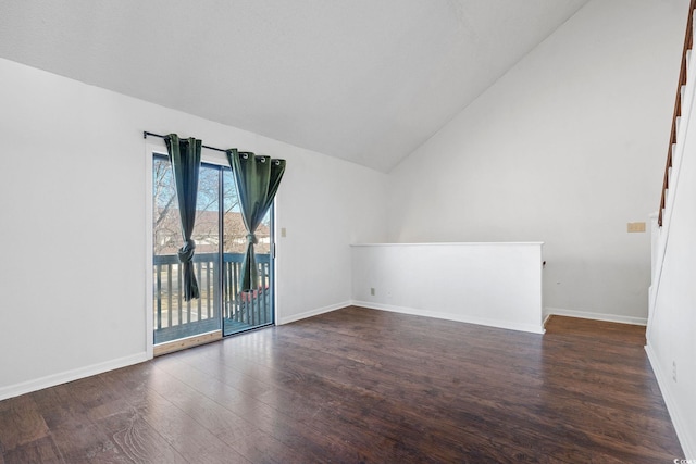 spare room featuring dark wood-type flooring and vaulted ceiling