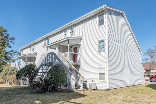 exterior space featuring a balcony, cooling unit, and a lawn