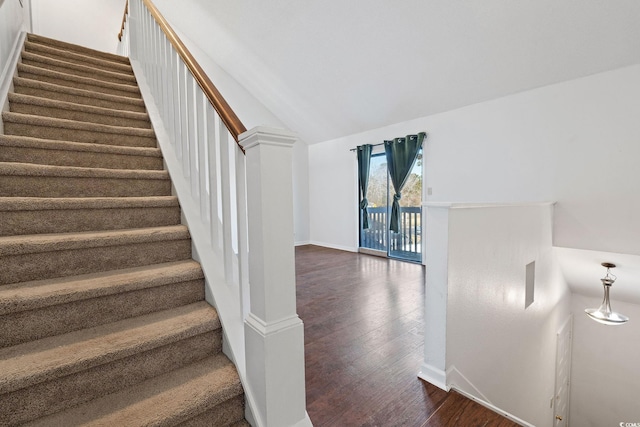 stairway with hardwood / wood-style flooring and lofted ceiling