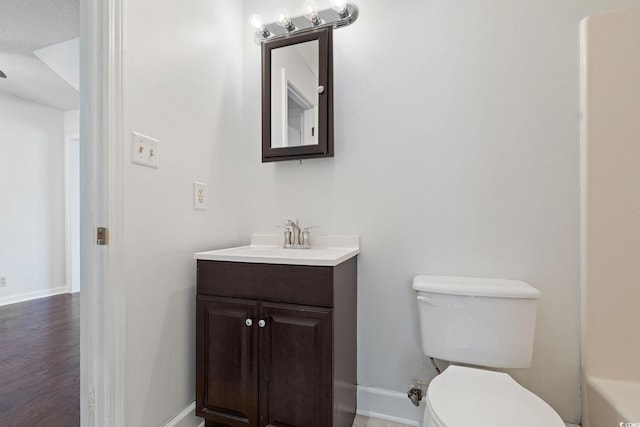 bathroom featuring vanity, wood-type flooring, and toilet