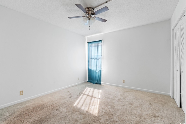 unfurnished bedroom with ceiling fan, a closet, light carpet, and a textured ceiling