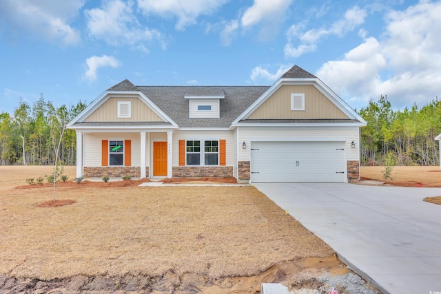 craftsman-style home featuring a shingled roof, concrete driveway, a garage, and a front yard