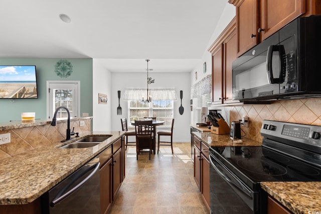 kitchen with decorative backsplash, stainless steel appliances, sink, and hanging light fixtures