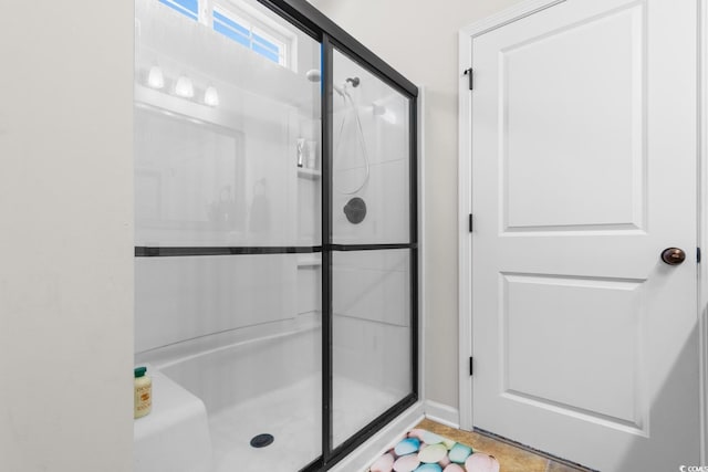 bathroom featuring a shower with shower door