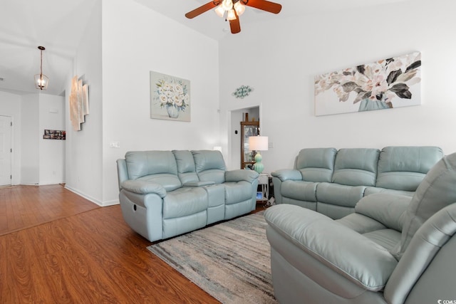 living room with a high ceiling, wood-type flooring, and ceiling fan