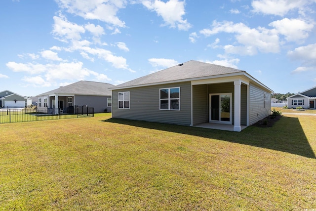 rear view of property featuring a yard, a patio area, and fence