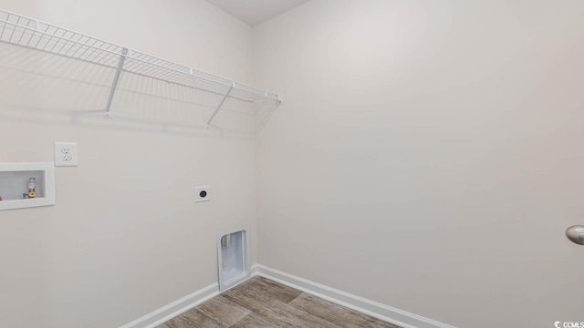 clothes washing area featuring hookup for a washing machine, hookup for an electric dryer, laundry area, wood finished floors, and baseboards