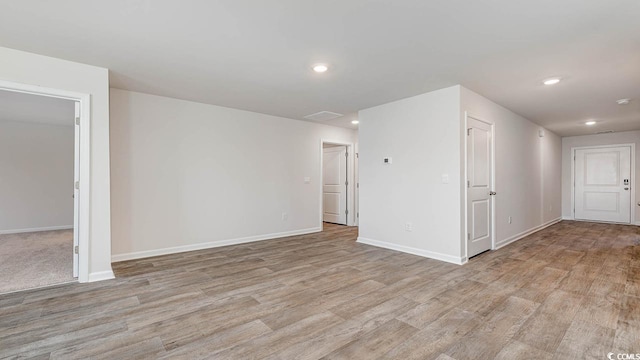 unfurnished room featuring light wood-style floors, recessed lighting, and baseboards