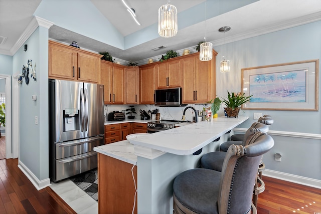 kitchen featuring crown molding, a breakfast bar, stainless steel appliances, decorative light fixtures, and kitchen peninsula