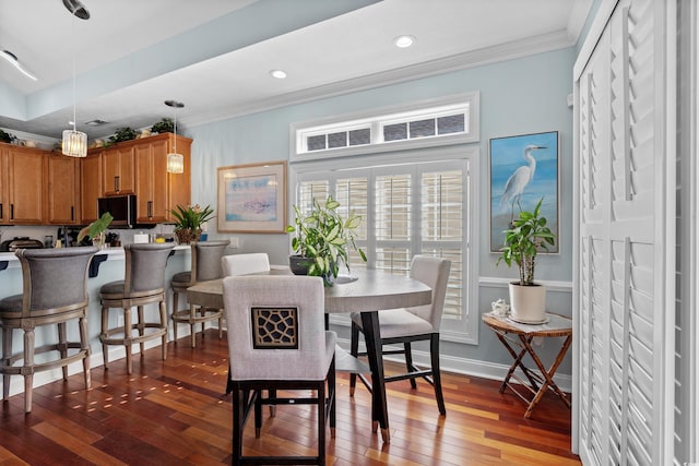 dining space featuring ornamental molding and dark hardwood / wood-style flooring