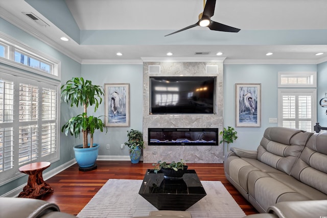 living room featuring dark hardwood / wood-style flooring, a fireplace, ornamental molding, and plenty of natural light