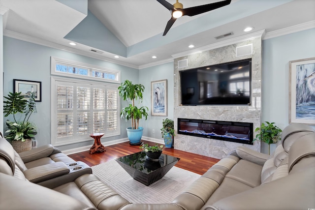 living room with ornamental molding, wood-type flooring, and a fireplace