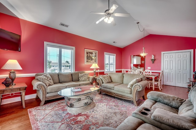 living room with ceiling fan, lofted ceiling, and light hardwood / wood-style floors