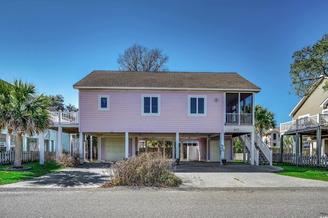 beach home featuring a carport, a garage, and a sunroom