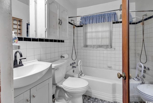 full bathroom featuring tile walls, toilet, and tiled shower / bath