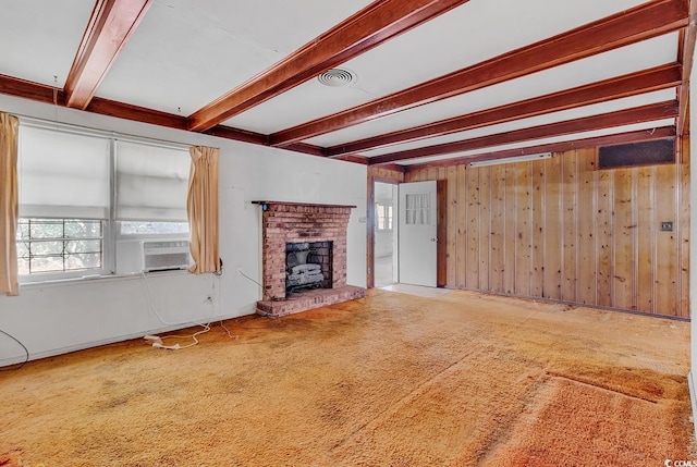 unfurnished living room with cooling unit, beam ceiling, a fireplace, and wooden walls